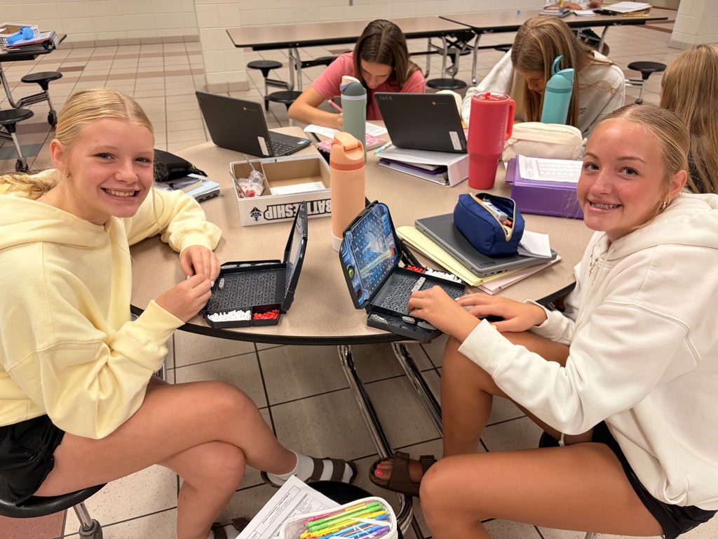 Two middle school students playing battleship.