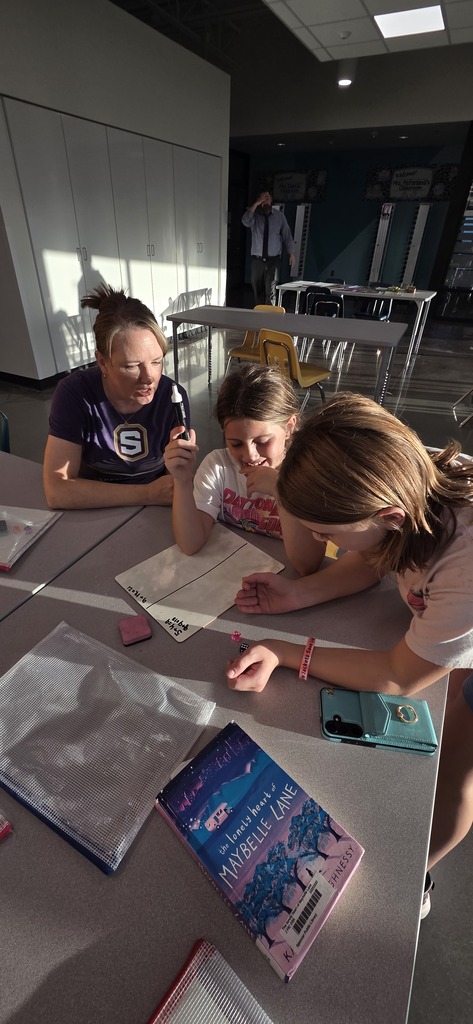 Elementary students doing a learning activity with a teacher.