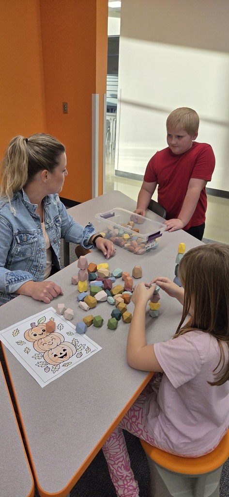 Elementary students doing a learning activity with a school employee.