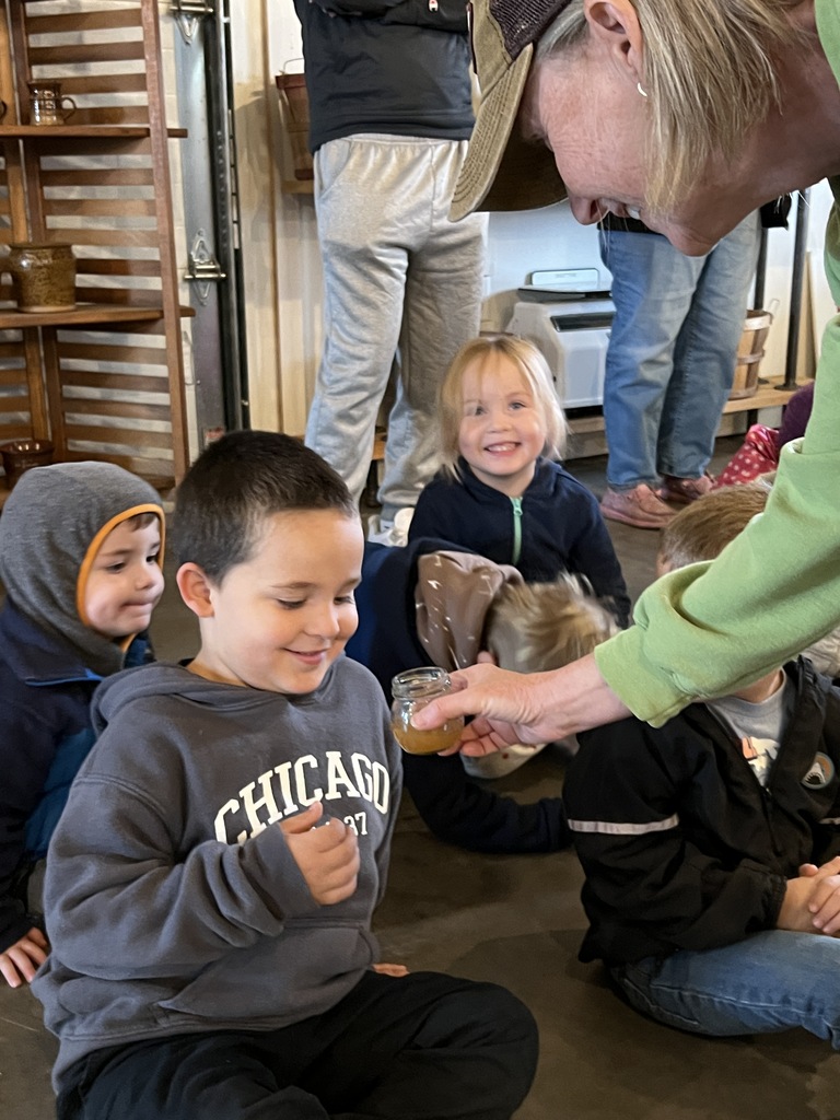 Preschool students learning about apples and cider at an apple orchard.