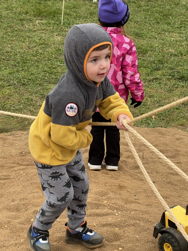 A preschool student playing at an orchard.