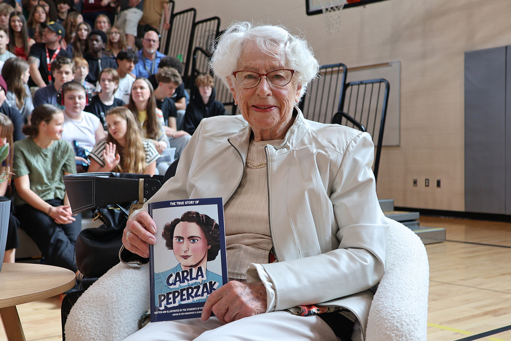 Carla Peperzak holds her graphic novel at a school assembly.