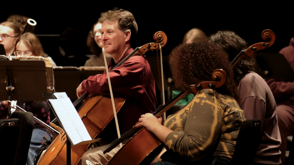 High school students and Spokane Symphony musicans practice together on stage.