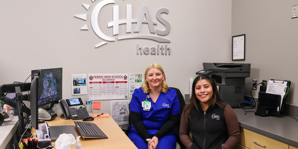 Two CHAS Health Clinic employees smile in the Ferris High School clinic.