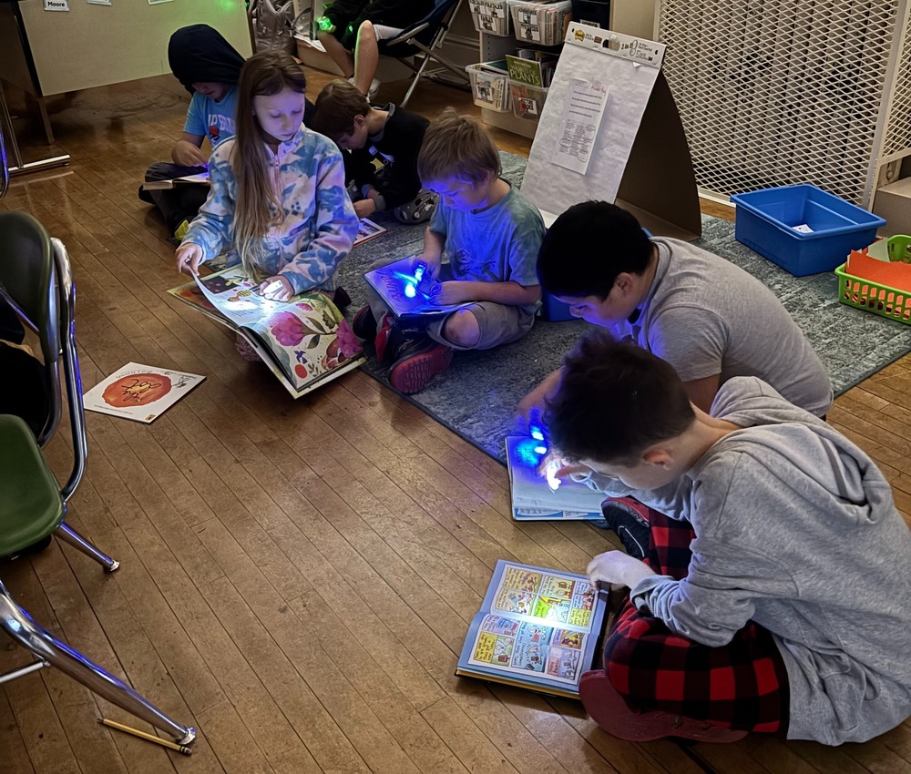 Students reading with flashlights