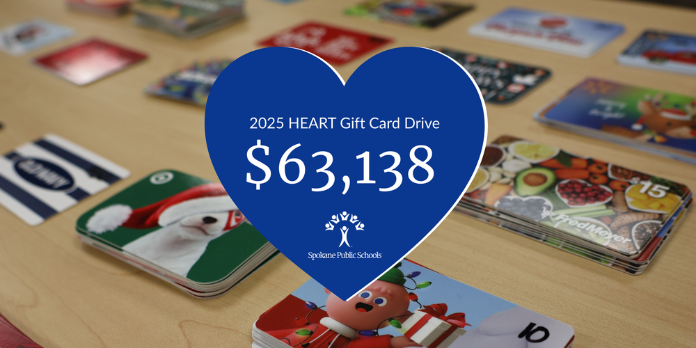 Piles of gift cards organized on a table with a blue heart graphic reading 2025 HEART Gift Card Drive, $63,238, Spokane Public Schools
