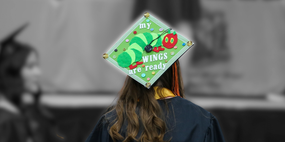 A graduate wears a cap decorared like the Hungriest Little Catepillar at a graduation ceremony.