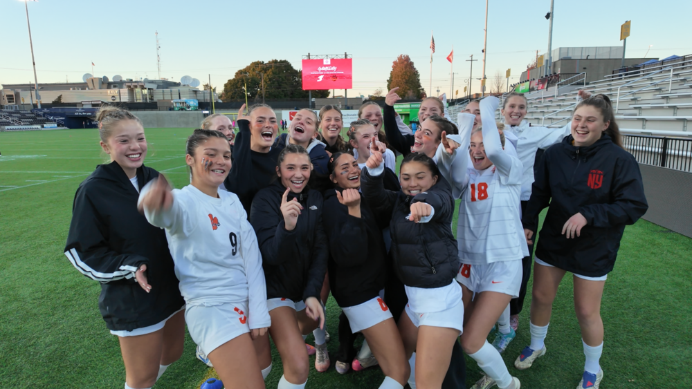 Lewis and Clark High School Girls' Soccer team celebrates on the field.