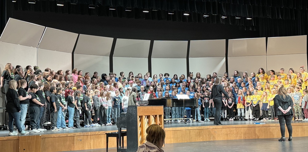 Students singing on stage.