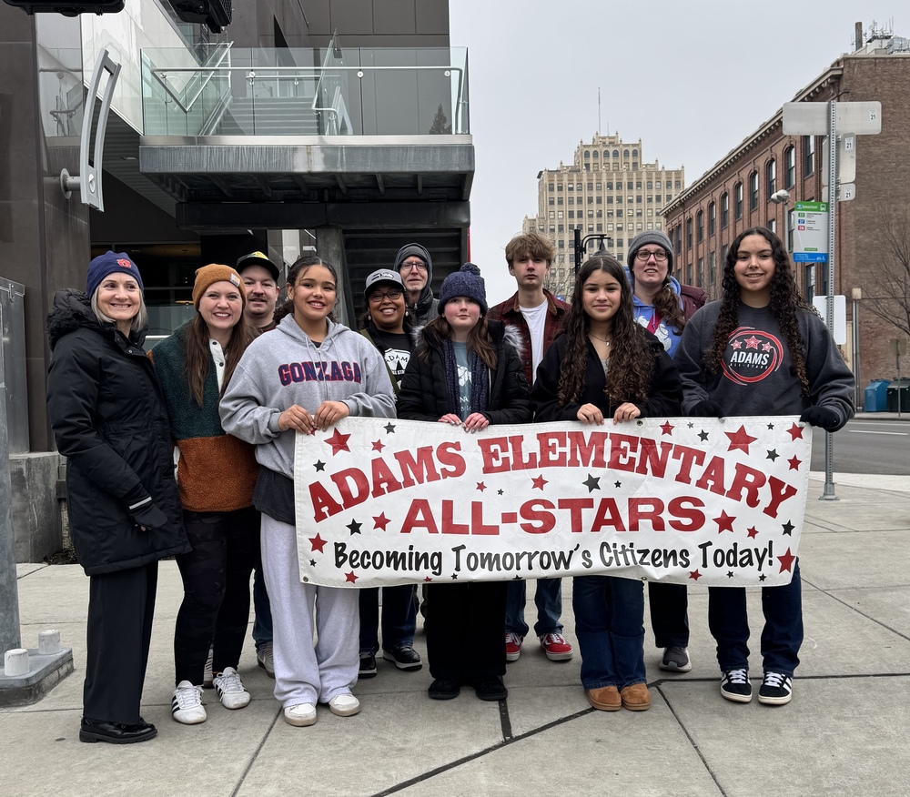 Students and adults with banner