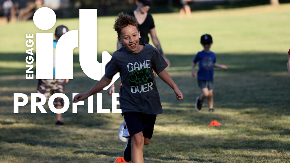 Smiling kid running with "Engage IRL Profile" words behind him