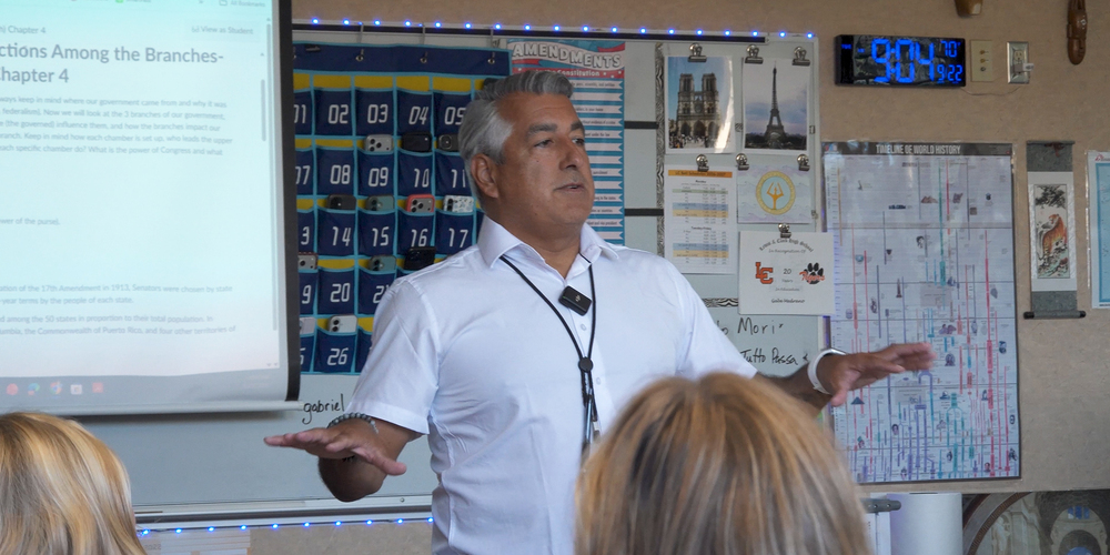 Gab Medrano teaches in front of high school students in his classroom.