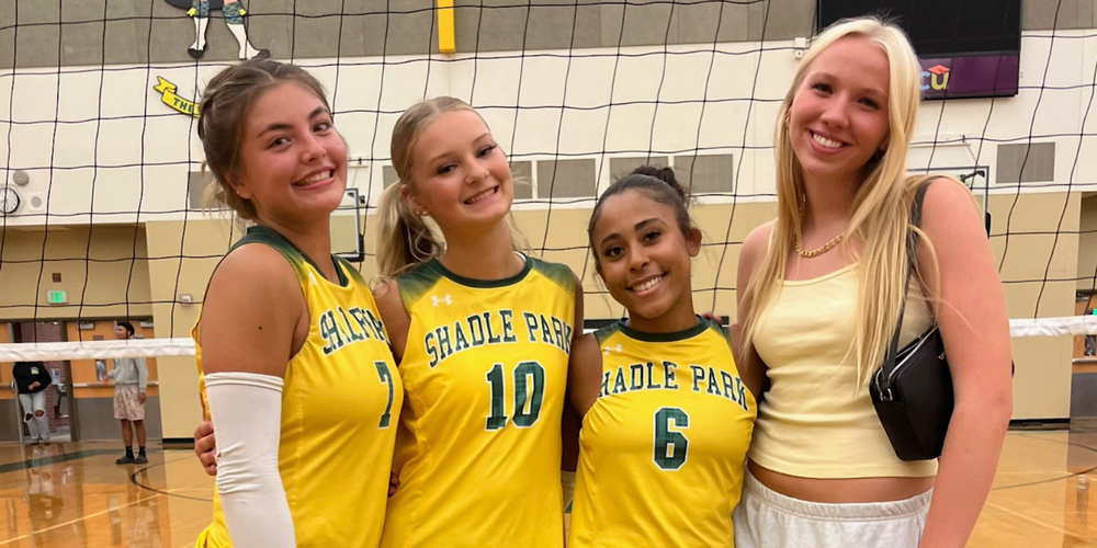Shadle Park student Maya Burnette smiles with volleyball teammates and friends on the court after a game.