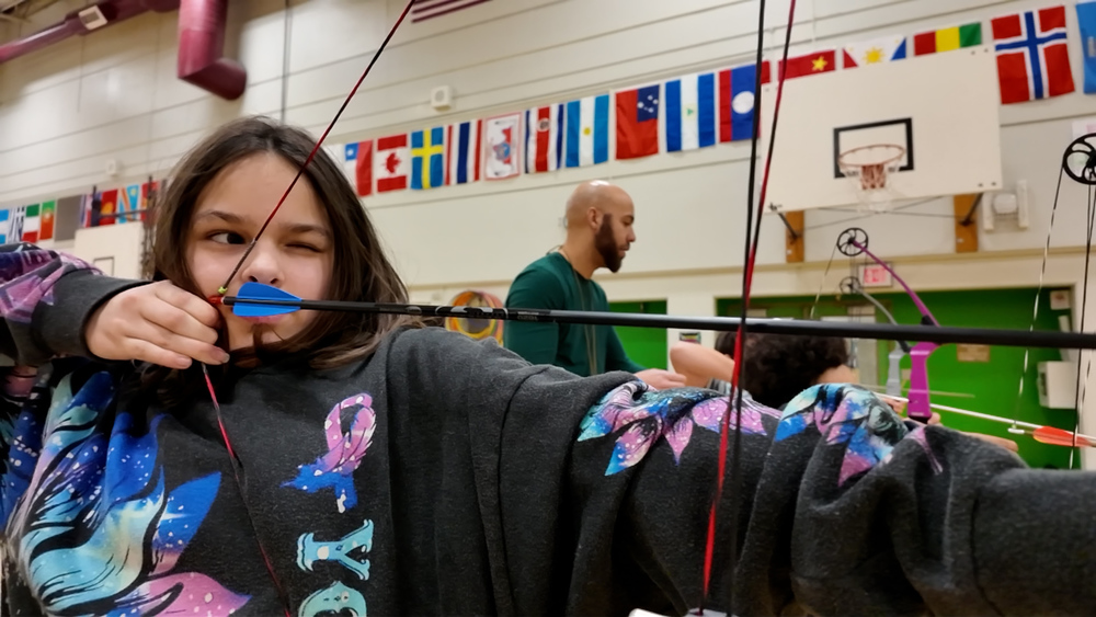 5th Grade student pulls bow in Archery club