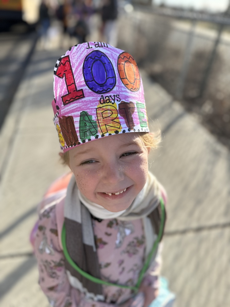 Student smiling with 100 days hat