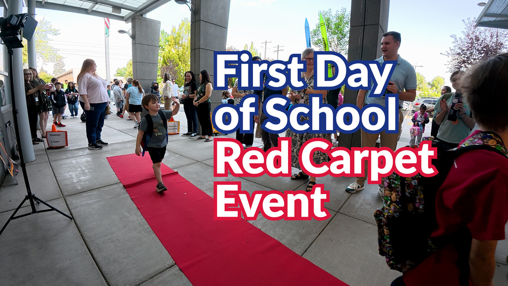 Elementary students walk the red carpet on the first day of school.