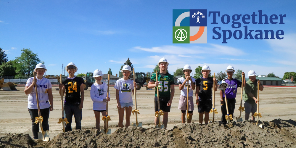 Eight high school student athletes and one adult wearing hard hats and hold gold shovels with bows smile on a construction site. The logo for Together Spokane is included.