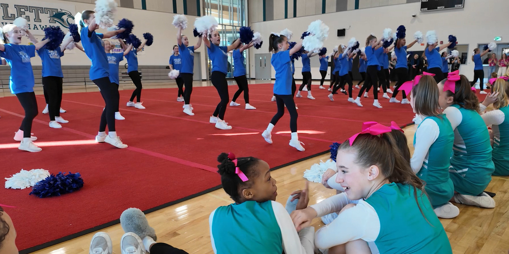 Flett Cheerleaders smile while they watch a performance by the Chase Middle School Drill Team