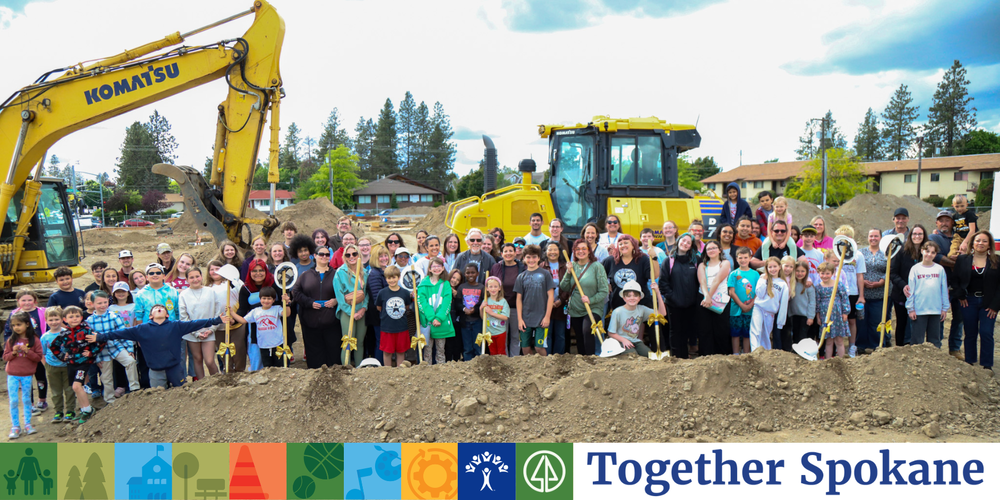Large group of people on a construction site with branding for Together Spokane.