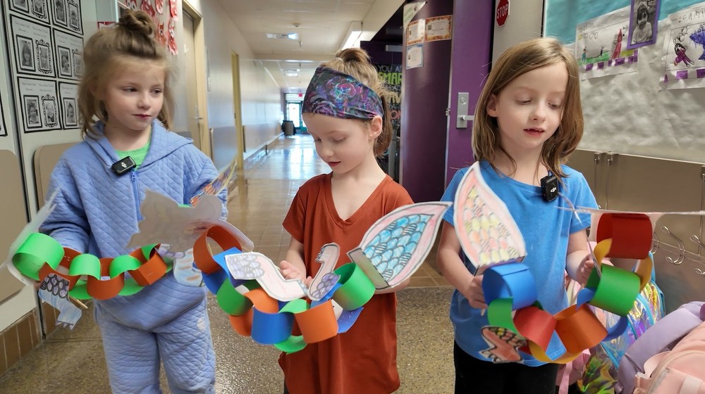 Three Holmes student hold paper dragons