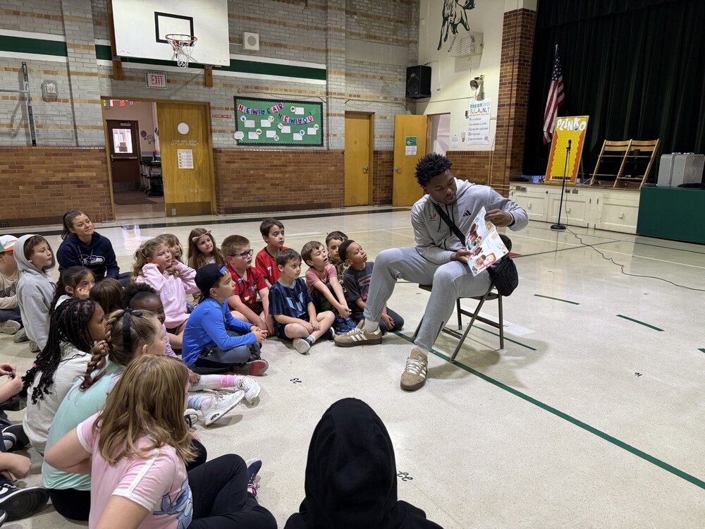 An Eastern Washington University men's basketball player reads to students.