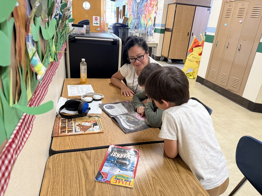 A volunteer reads with first grade students
