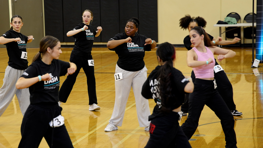 High school dancers practice in a gym.