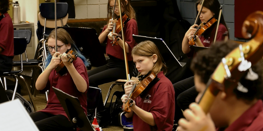 Garry Middle School orchestra students play in a classroom.