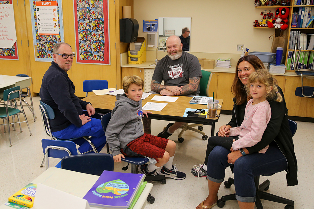 Family with teacher looking at camera