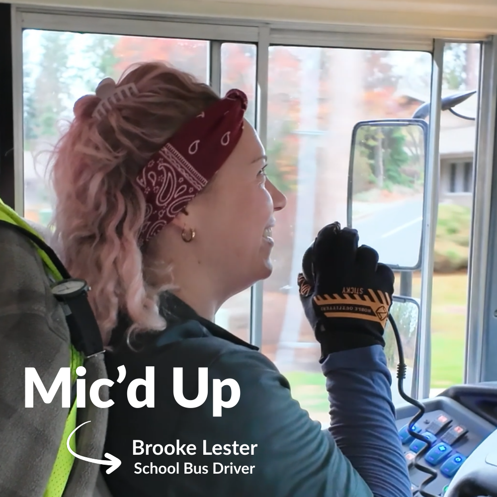 School bus driver Brooke Lester speaks into an intercom while she drives and smiles for a Mic'd Up video.