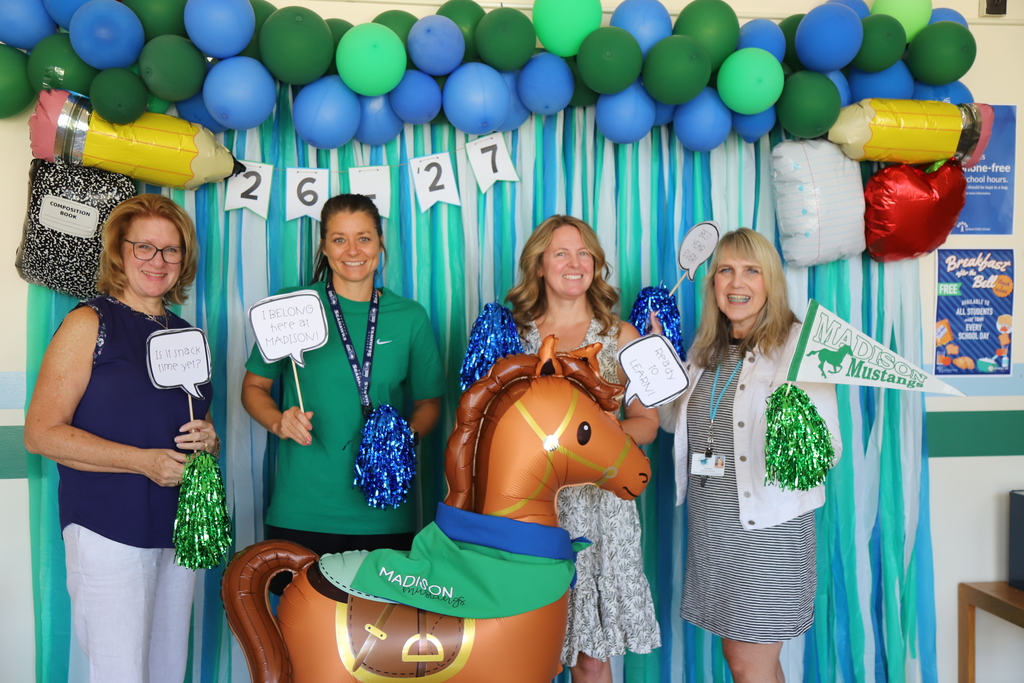 Madison Elementary School staff pose with a festive back to school photo backdrop.