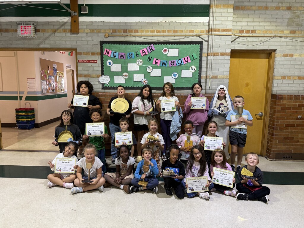 Students holding golden awards at our assembly.