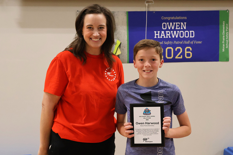 Erin Rogers smiles with Owen Harwood, who is holding an award.