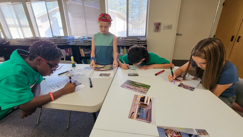 Elementary students create collages with photos, drawings and text to help design a new school.