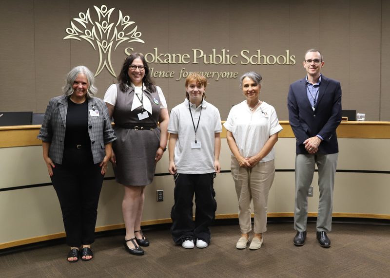 A student poses with the Spokane Public Schools Board of Directors.