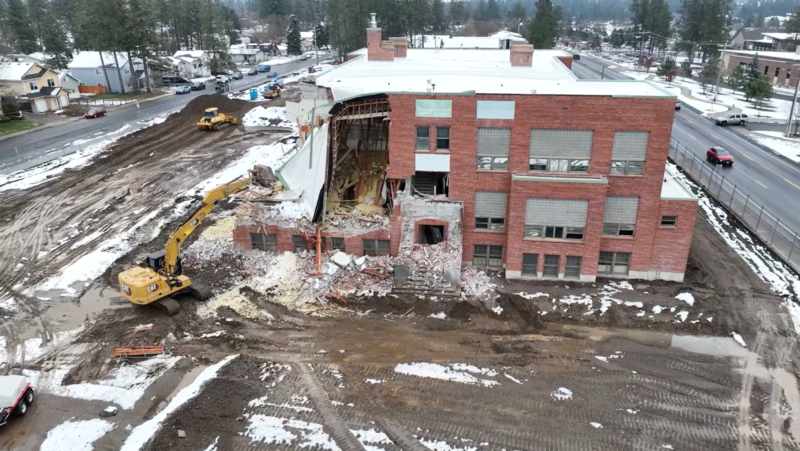 Adams Elementary School building in the process of being demolished by a crane. Aerial view.