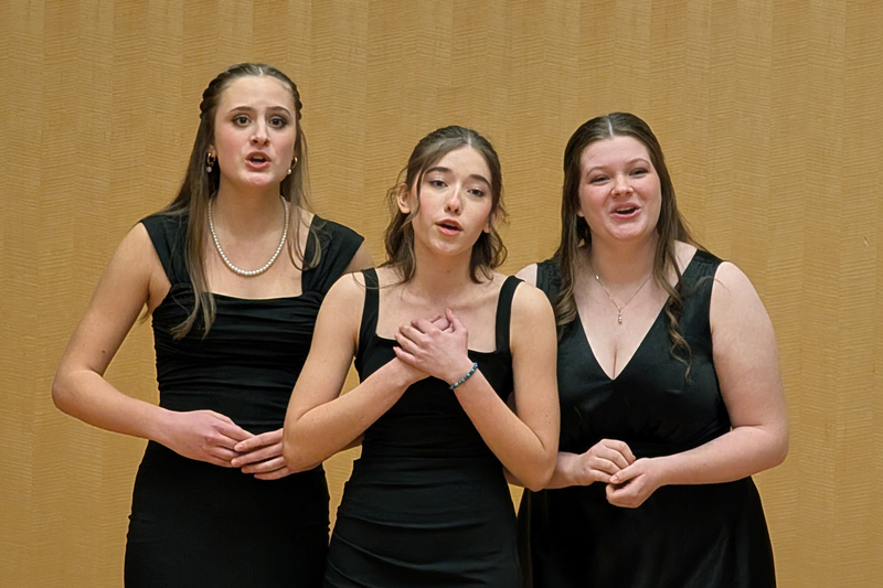 Three Ferris High School student sing at a competition.