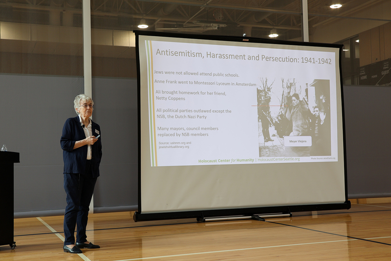 Ingrid Steppic stands next to a presentation about antisemitism in 1941-1942 in the Netherlands. 