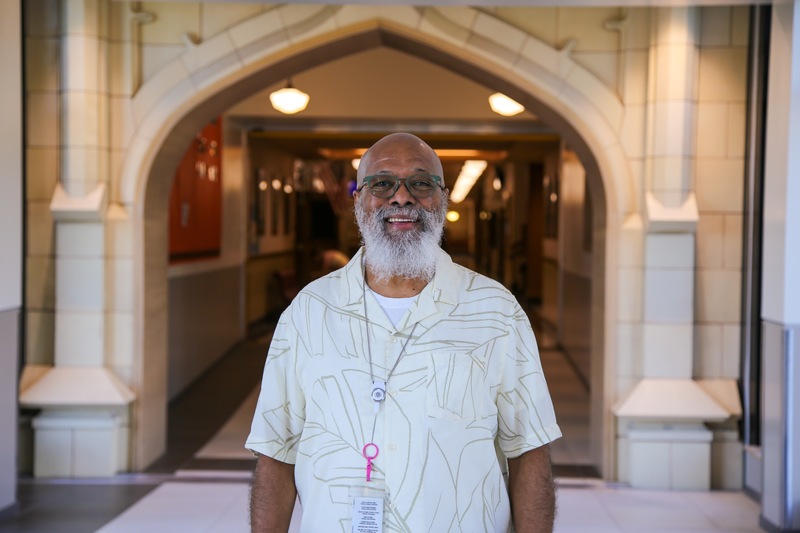 Man standing in the hallway of a school. Angus Nunes.
