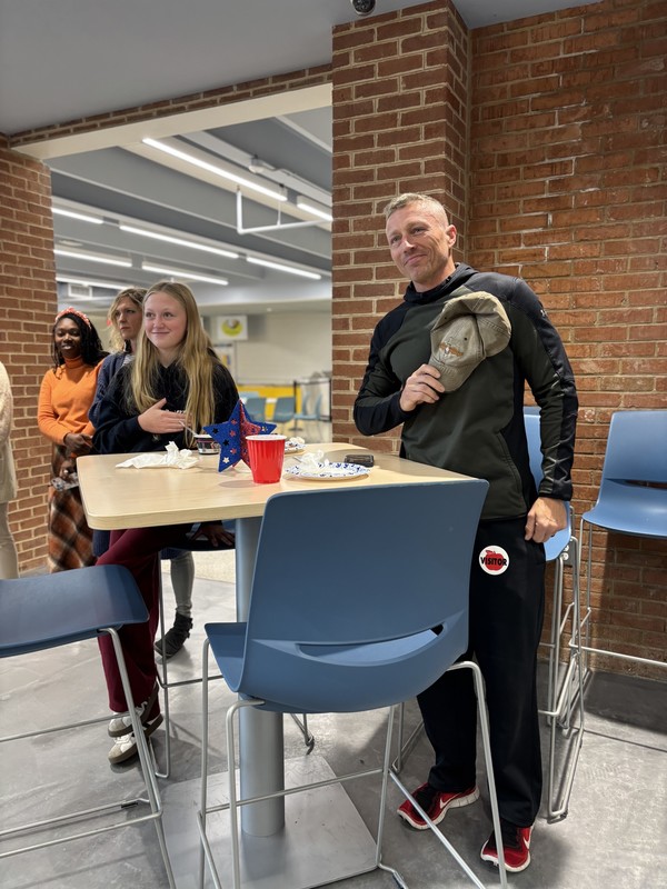 A father and student are standing during the pledge