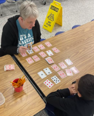 Mrs. O'Dell playing a card game with a student
