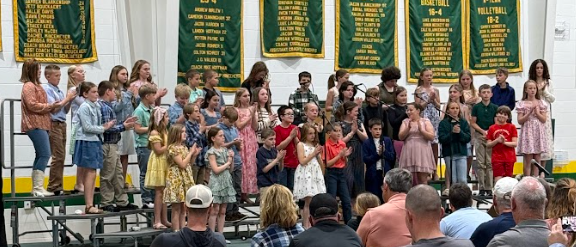 Students on a stage singing