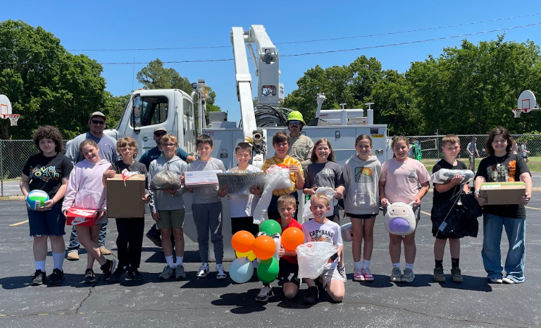 students standing in front of a boom truck getting ready for the egg drop challenge