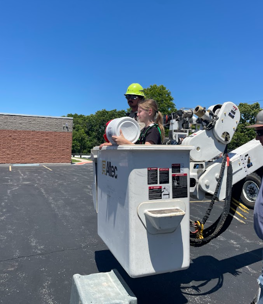 a student going up in a boom truck for the egg drop challenge