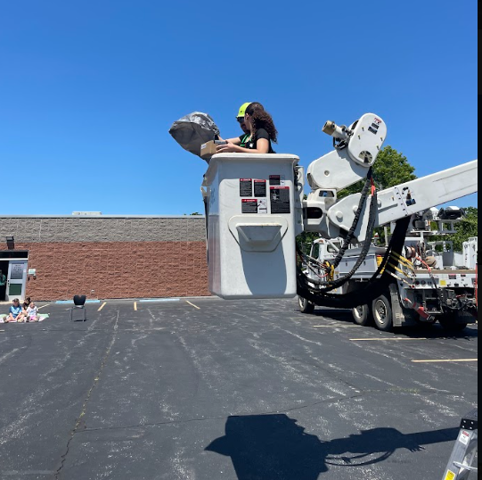 a student going up in a boom truck for the egg drop challenge