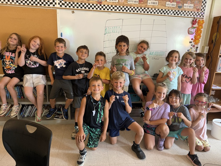 2nd grade students with shark teeth necklaces 