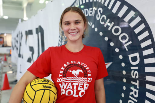 Addie Gwaltney smiling holding a volleyball at her side