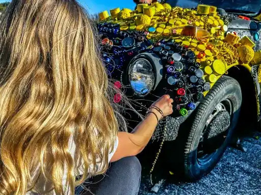 student gluing beads onto an art car