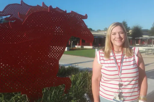 Lindley Amarantos smiling next to a mustang sculpture