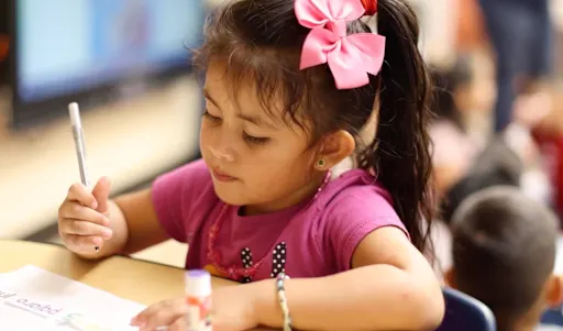 young student writing with a pen